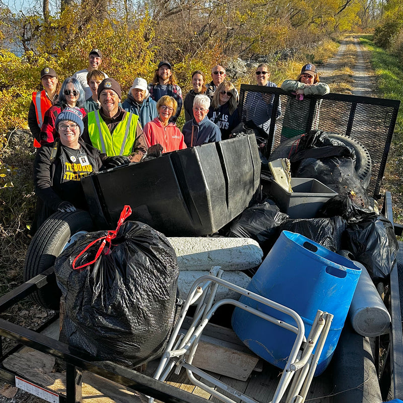 Group of volunteers with trash collection in a fall near a shoreline